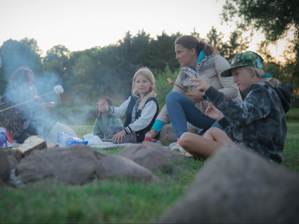 Ørsted Outdoor Naturcamping, børn og voksne omkring et bål