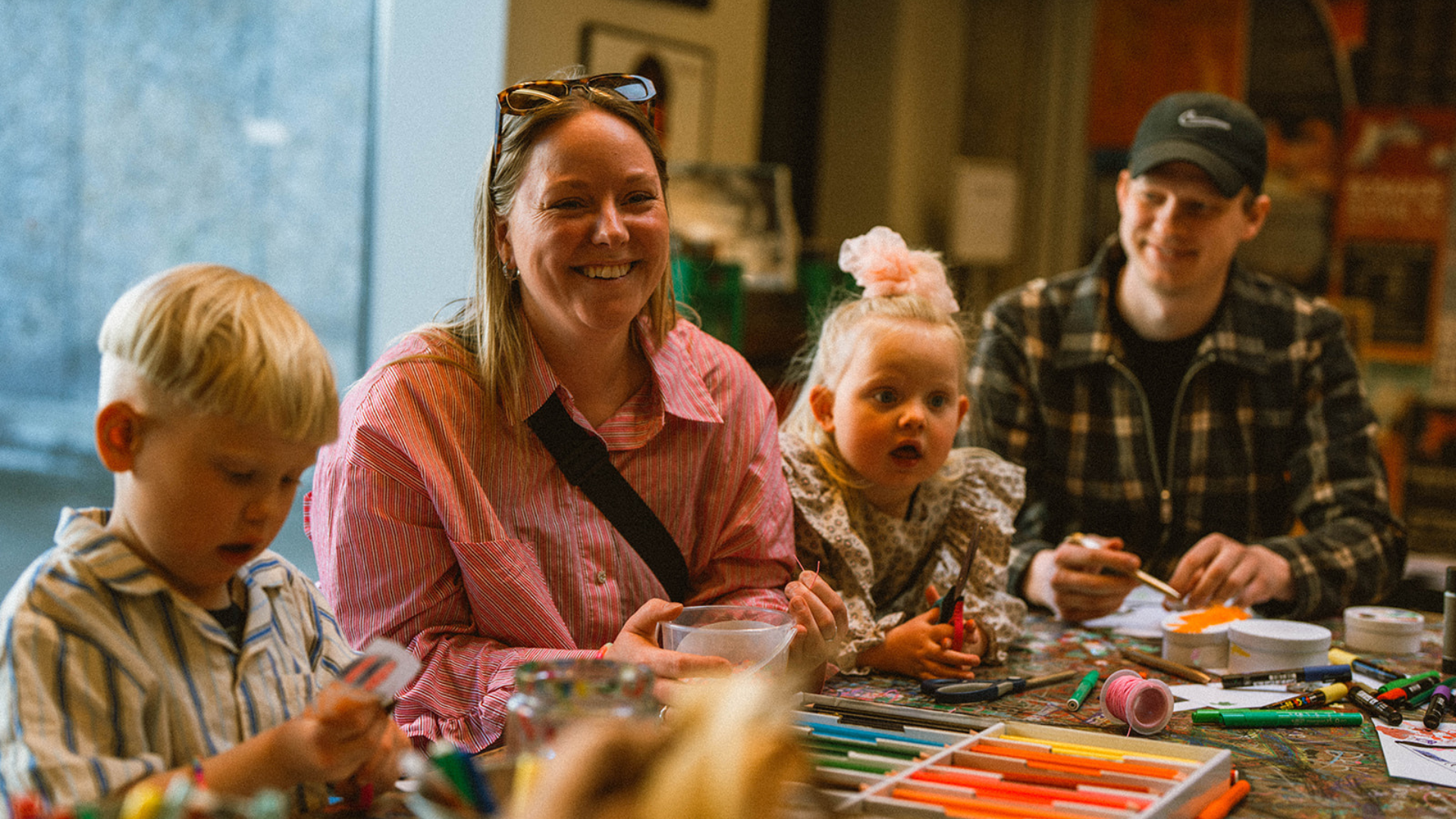 Familie deltager i kreativ workshop med tegning og klippeaktiviteter på Rockmuseet i Roskilde.
